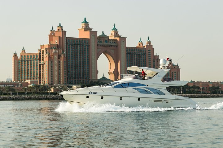 Experience the stunning Dubai skyline aboard a private luxury yacht gliding past iconic landmarks like the Atlantis hotel and enjoy swimming or sunbathing in this serene aquatic escape.